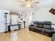 Living room featuring light wood floors, vintage wallpaper borders and outdated furnishings at 8523 Hamster Dr, Zephyrhills, FL 33540