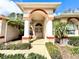 Close-up of a home's front entrance showcasing brick pavers, decorative wreath and well-maintained landscaping at 9006 Callaway Dr, Trinity, FL 34655