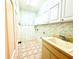 Spacious laundry room with utility sink, overhead storage, and patterned walls at 9006 Callaway Dr, Trinity, FL 34655