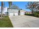 Exterior view of the house with a long driveway, two garages, and well-maintained landscaping at 9920 Alavista Dr, Gibsonton, FL 33534