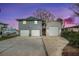 Waterfront home featuring a two-car garage and a separate garage with a carport at twilight hour at 9920 Alavista Dr, Gibsonton, FL 33534