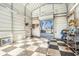 Inside view of a spacious garage featuring a checkered floor, a roll-up door and ample space at 9920 Alavista Dr, Gibsonton, FL 33534