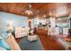 Bright, open living space features wood ceilings and comfortable seating, seamlessly connecting to the kitchen and dining area at 9920 Alavista Dr, Gibsonton, FL 33534