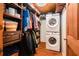 Well-organized walk-in closet features custom shelving and a stacked washer and dryer unit at 9920 Alavista Dr, Gibsonton, FL 33534