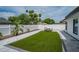 Landscaped backyard with artificial turf, paved walkway, and seating area for entertaining at 10064 82Nd St, Seminole, FL 33777