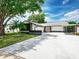 Charming single Gathering home with a well-maintained lawn, lush trees and extended driveway at 10064 82Nd St, Seminole, FL 33777