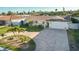 Beautiful single-story home featuring a brick driveway, lush landscaping, and an attached two-car garage at 102 23Rd St, Belleair Beach, FL 33786
