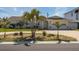 Charming home featuring a well-manicured lawn, brick driveway, and mature palm trees at 102 23Rd St, Belleair Beach, FL 33786