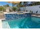 Relaxing pool and hot tub featuring decorative blue tile and waterfall feature at 102 23Rd St, Belleair Beach, FL 33786