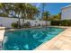 Backyard pool is surrounded by lush landscaping and a privacy fence at 102 23Rd St, Belleair Beach, FL 33786