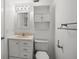 Bathroom featuring a vanity, wall cabinet, and a toilet, all complemented by white walls and tile flooring at 10467 Larchmont N Pl, Pinellas Park, FL 33782