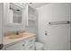 Clean bathroom with vanity storage, mirrored cabinet, towel rack, and toilet with neutral color palette at 10467 Larchmont N Pl, Pinellas Park, FL 33782