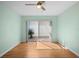 Bright bedroom with a ceiling fan, light green walls, laminate wood flooring and a sliding glass door to outdoor patio at 10467 Larchmont N Pl, Pinellas Park, FL 33782
