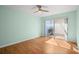 Light-filled bedroom with a ceiling fan, laminate wood flooring, and a sliding glass door to outdoor patio at 10467 Larchmont N Pl, Pinellas Park, FL 33782