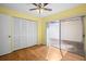 Bedroom featuring laminate floors, ceiling fan, and sliding doors with access to patio at 10467 Larchmont N Pl, Pinellas Park, FL 33782