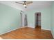 Bedroom with wood laminate flooring, light green walls, ceiling fan, and an ensuite bathroom and closet at 10467 Larchmont N Pl, Pinellas Park, FL 33782