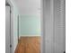 Bedroom with light green walls, wood laminate flooring, and a spacious closet, offering comfort and functionality at 10467 Larchmont N Pl, Pinellas Park, FL 33782
