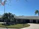 Inviting home featuring a lush front lawn, palm trees, and a paver driveway at 10467 Larchmont N Pl, Pinellas Park, FL 33782