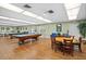 Bright community recreation room with game tables, plants, and lots of light at 10467 Larchmont N Pl, Pinellas Park, FL 33782