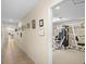 Hallway leading to community gym with framed art along the walls and tile flooring at 10467 Larchmont N Pl, Pinellas Park, FL 33782