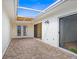 Enclosed brick patio with double doors, skylight, and neutral walls at 10467 Larchmont N Pl, Pinellas Park, FL 33782