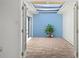 A view of the enclosed patio featuring a brick floor, blue accent wall, and skylight at 10467 Larchmont N Pl, Pinellas Park, FL 33782