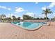 Outdoor community pool featuring ample seating and a tranquil setting on a sunny day at 10467 Larchmont N Pl, Pinellas Park, FL 33782