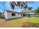 View of the side of the house and screened lanai from the grassy backyard at 105 Lotus Cir, Safety Harbor, FL 34695