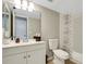 Bathroom with white vanity, decorative mirror, and bathtub with shower with patterned shower curtain at 105 Lotus Cir, Safety Harbor, FL 34695