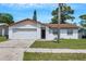 Charming one-story home with a well-maintained lawn and attached garage, perfect for a starter home or downsizing at 105 Lotus Cir, Safety Harbor, FL 34695