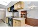Modern kitchen with granite countertops, stainless steel appliances, and an island, seamlessly flowing into the living area at 105 Lotus Cir, Safety Harbor, FL 34695