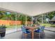 Screened lanai with a dining table, blue chairs, and views of the lush backyard at 105 Lotus Cir, Safety Harbor, FL 34695