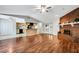 Open concept living room adjacent to the kitchen featuring a brick fireplace and gleaming hardwood floors for easy entertaining at 105 Lotus Cir, Safety Harbor, FL 34695