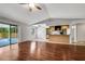 Inviting open living space with wood floors, neutral paint, and adjacent kitchen and enclosed outdoor patio at 105 Lotus Cir, Safety Harbor, FL 34695