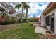 Private backyard featuring mature trees, a paved patio with outdoor seating, and lush green lawn at 1273 Mission Cir, Clearwater, FL 33759