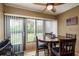 Cozy dining area with a wooden table, four chairs, a large window with vertical blinds, and an adjacent door at 1273 Mission Cir, Clearwater, FL 33759