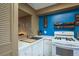 Bright, well-lit kitchen area featuring white cabinetry and a striking blue accent wall at 1273 Mission Cir, Clearwater, FL 33759