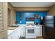 Efficient kitchen with white cabinetry, stainless steel sink, and wall mounted spice racks, complemented by wood-look floors at 1273 Mission Cir, Clearwater, FL 33759