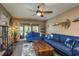 Relaxing living room featuring plush blue sofas, ceiling fan, and natural light at 1273 Mission Cir, Clearwater, FL 33759