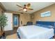 Cozy main bedroom showcasing a ceiling fan, blue upholstered bed frame, and tranquil beach-themed wall art at 1273 Mission Cir, Clearwater, FL 33759