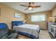 Bright main bedroom featuring a large window, blue upholstered bed frame, and ceiling fan for optimal air flow at 1273 Mission Cir, Clearwater, FL 33759