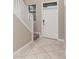 Foyer features neutral tile flooring, white trim, a staircase with carpeted steps, and natural light at 1555 Tallulah Ter, Wesley Chapel, FL 33543