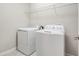 Bright laundry room featuring modern appliances and tile floors at 1555 Tallulah Ter, Wesley Chapel, FL 33543