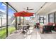 Screened patio featuring a dining area with an umbrella and comfortable seating, perfect for outdoor gatherings and relaxation at 1598 Tallulah Ter, Wesley Chapel, FL 33543