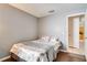 This is a furnished bedroom with gray walls, wood floors and a comfortable bed with floral bedding at 1731 Elk Spring Dr, Brandon, FL 33511