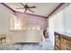 The main bedroom has purple accent walls, ceiling fan, and lots of natural light, creating a cozy retreat at 1731 Elk Spring Dr, Brandon, FL 33511