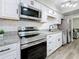 Modern kitchen featuring white cabinets, stainless steel appliances, granite countertops, and tile backsplash at 1884 Clearbrooke Dr # 1884, Clearwater, FL 33760