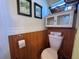 Charming bathroom with wood paneling and white cabinets, featuring a toilet and decor at 2331 Belleair Rd # 527, Clearwater, FL 33764