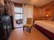 Inviting bedroom with wooden walls, featuring a plush chair and sliding glass doors at 2331 Belleair Rd # 527, Clearwater, FL 33764