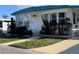 Charming home featuring white siding, teal roof, landscaped yard, and a welcoming front entrance at 2331 Belleair Rd # 527, Clearwater, FL 33764